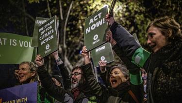 Menschen auf dem Klimaprotest in Madrid halten Schilder hoch, auf denen sie fordern jetzt zu handeln