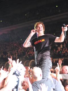 Campino steht mit Oxfam-Shirt auf einer Bühne