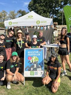 Gruppenbild Lollapalooza 2024 Eine Gruppe von Menschen steht vor einem Festivalstand von Oxfam
