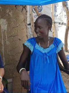 Die Direktorin von Oxfam in Afrika, Fati N'zi-Hassane und Nyaguka Jiek unterhalten sich. Die Direktorin von Oxfam in Afrika, Fati N'zi-Hassane (links, trägt ein dunkelblaues Hemd und eine neongelbe Weste) und Nyaguka Jiek (rechts, trägt ein blaues Kleid) sitzen auf weißen Plastikstühlen nebeneinander und unterhalten sich.