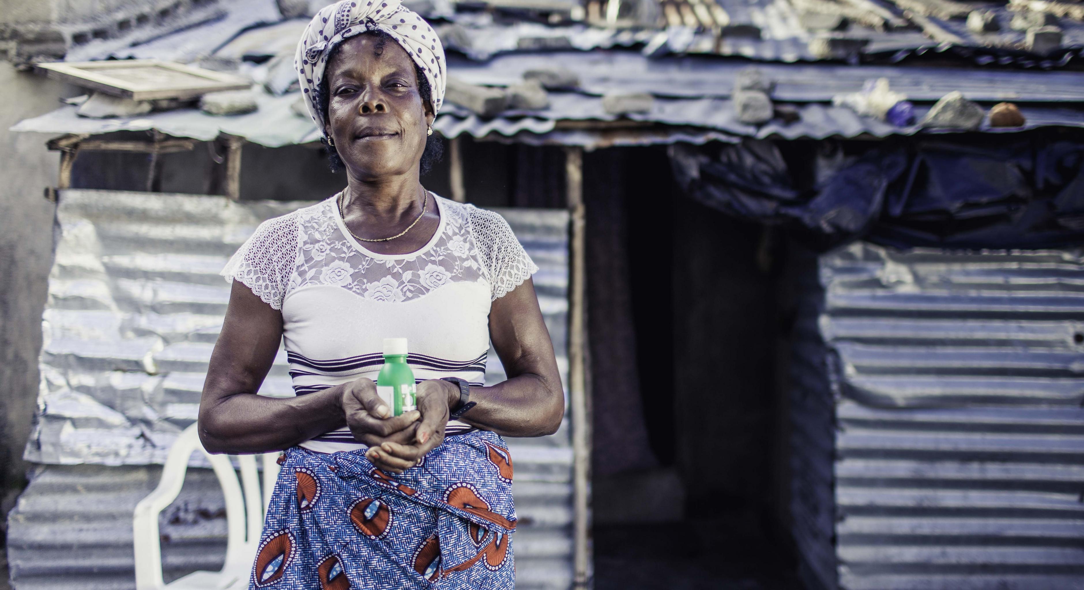Maria Mussanharuca hält eine Flasche Chlor, die sie von Oxfam erhalten hat