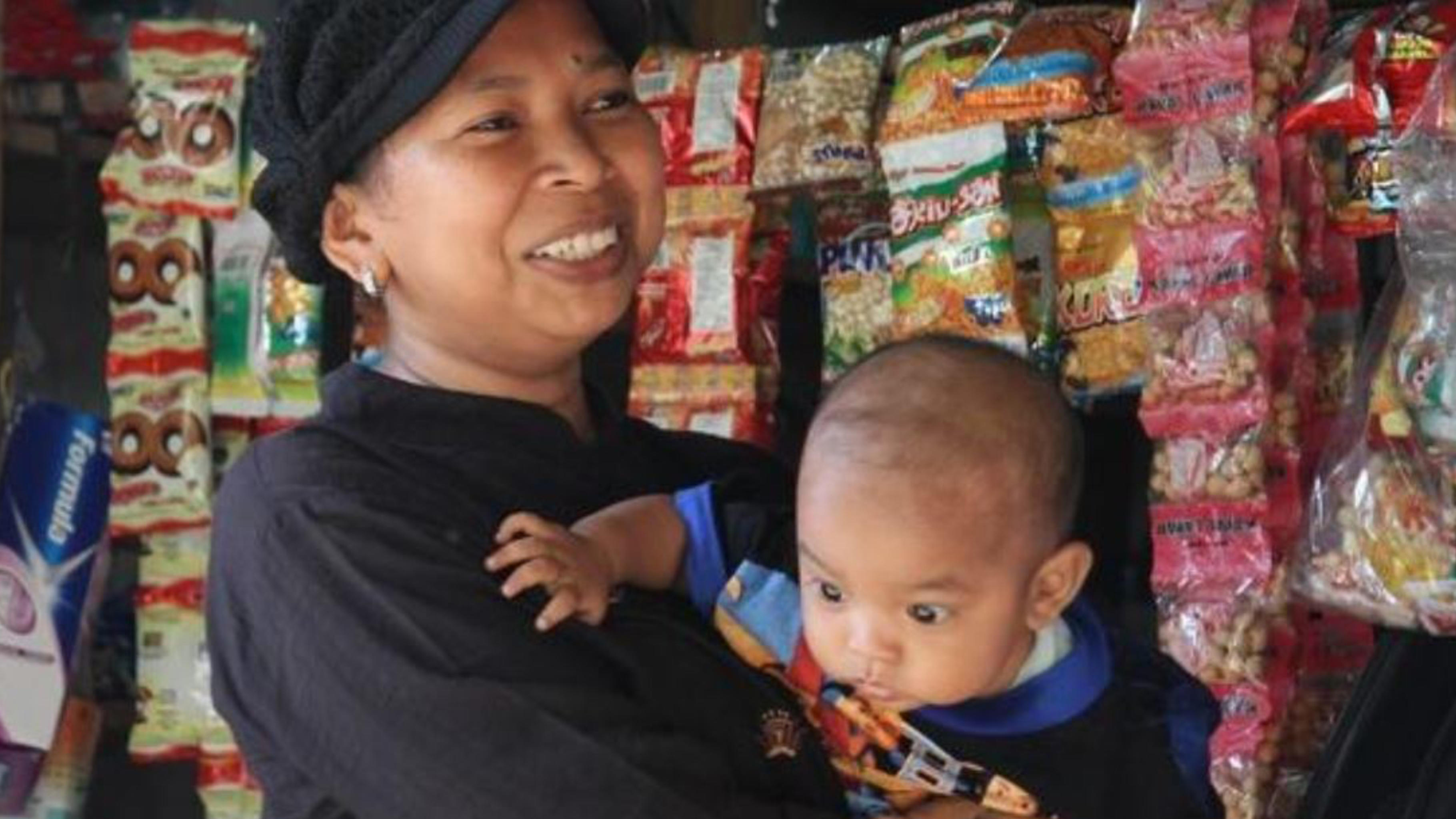 Rusiani mit ihrem Sohn Habil in ihrem Geschäft in Indonesien