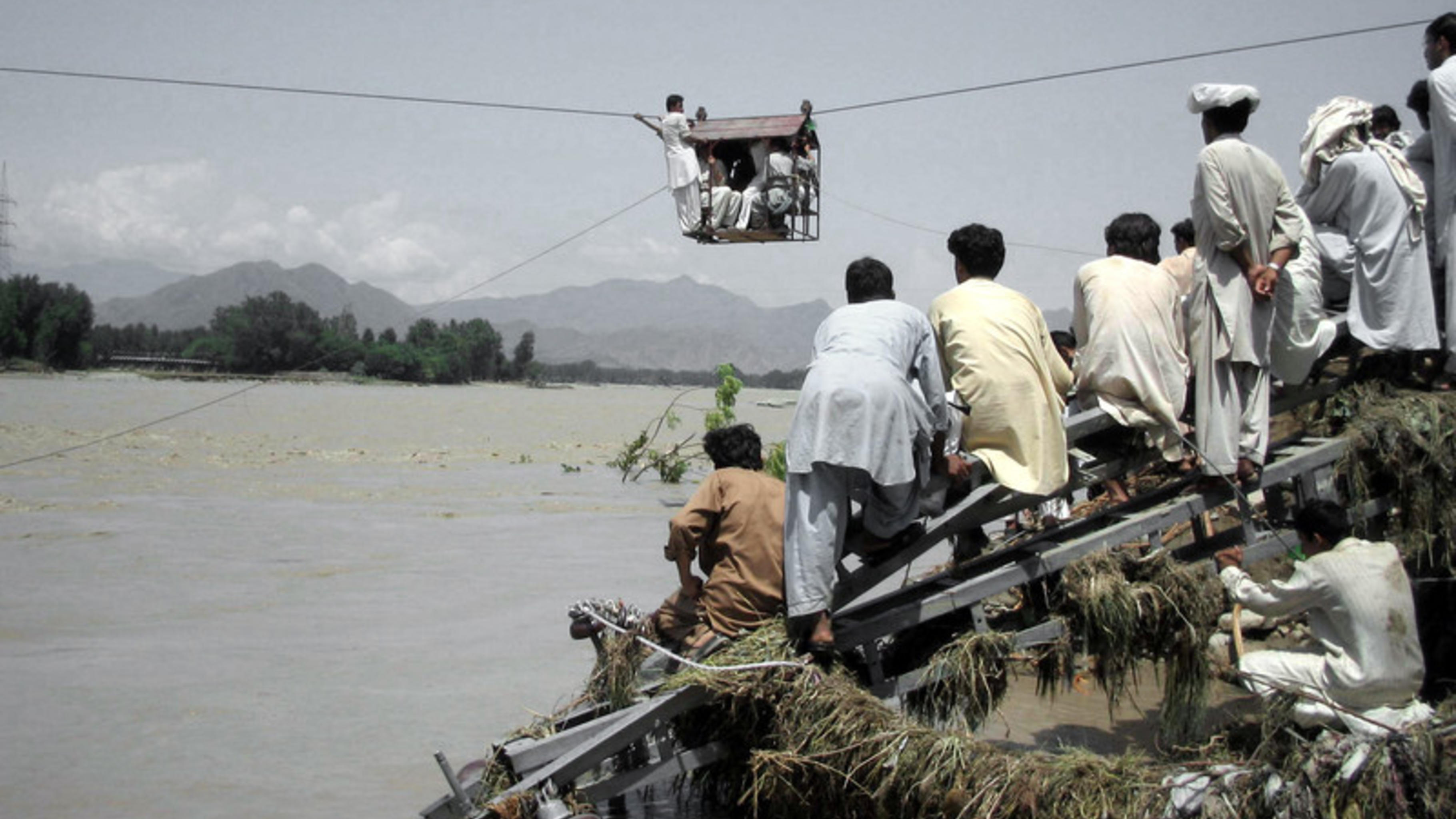 Foto: Menschen nutzen eine Seilbahn zur Flucht vor dem Wasser.