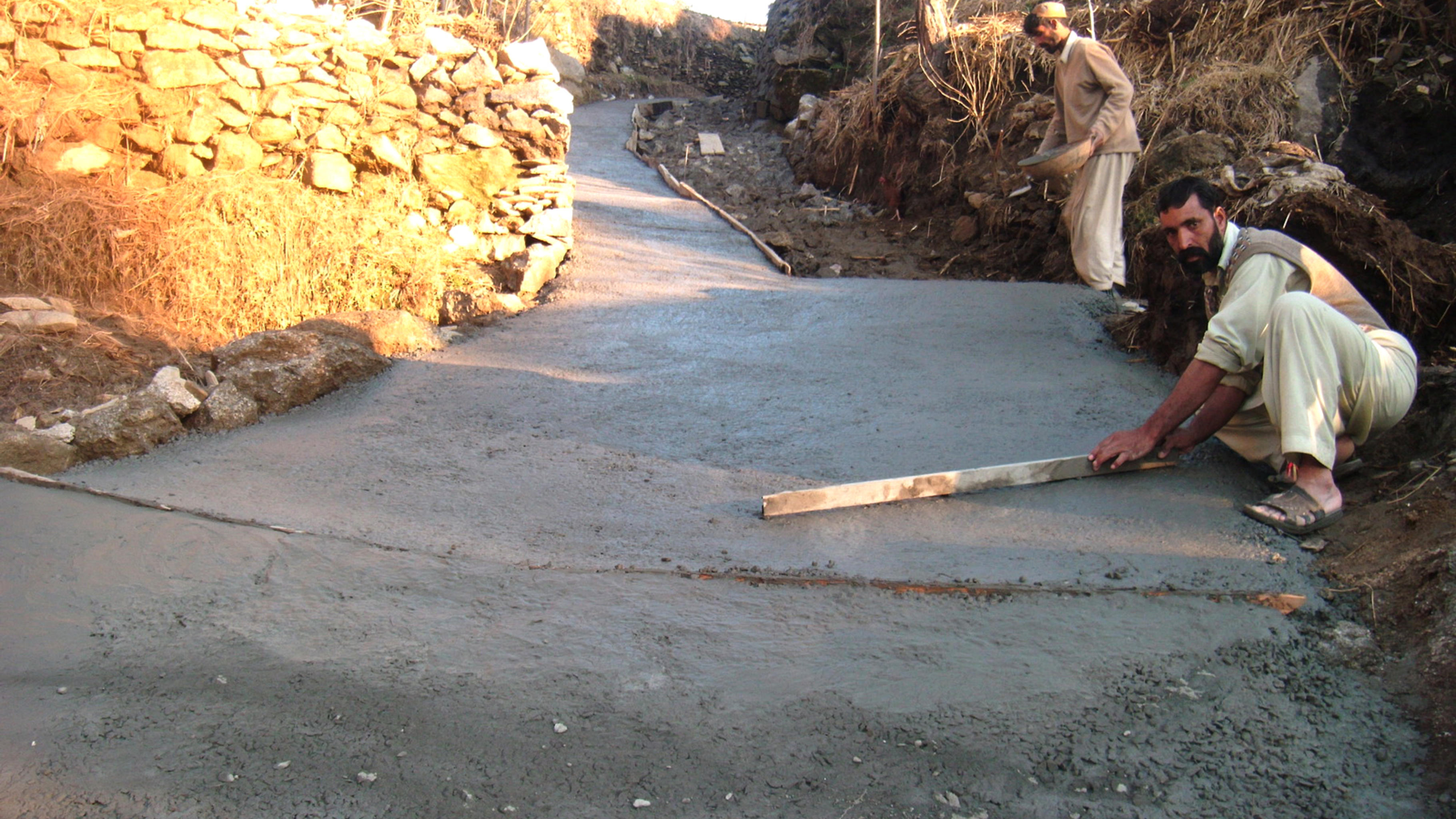 Die Männer bauen mit SAIBAANs Unterstützung eine Straße: