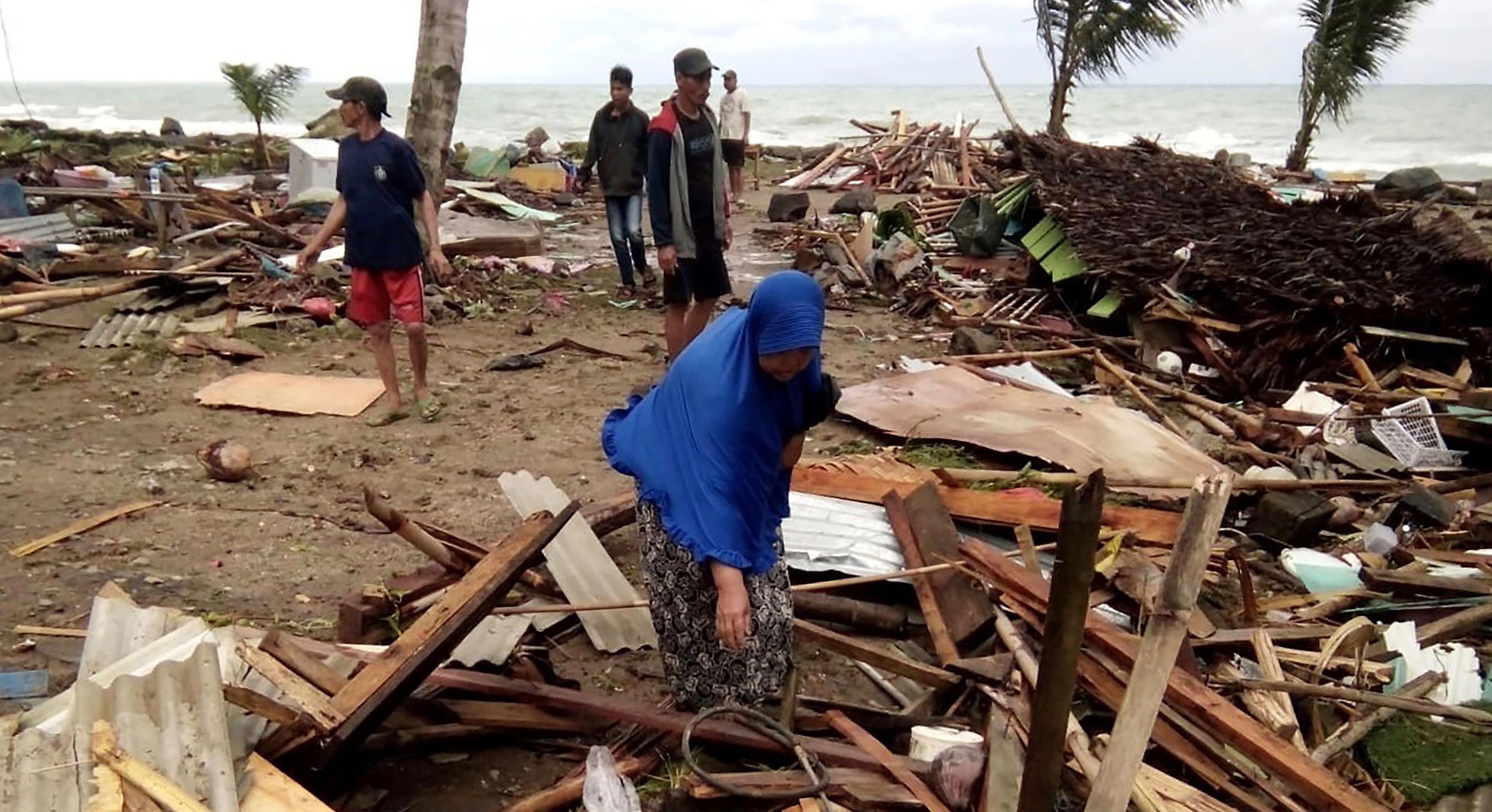 Bewohner inspizieren die Schäden an ihren Häusern am Strand von Carita, nachdem das Gebiet am 22. Dezember von einem Tsunami heimgesucht wurde.