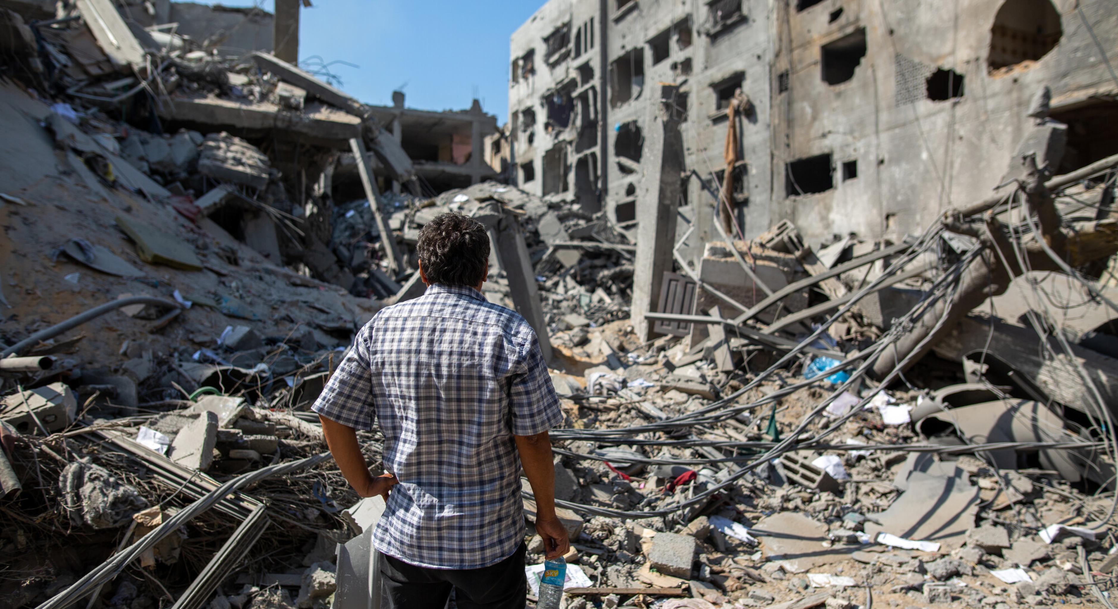 Ein palästinensicher Mann steht vor einem durch israelische Bombenangriffe zerstörten Haus in Gaza