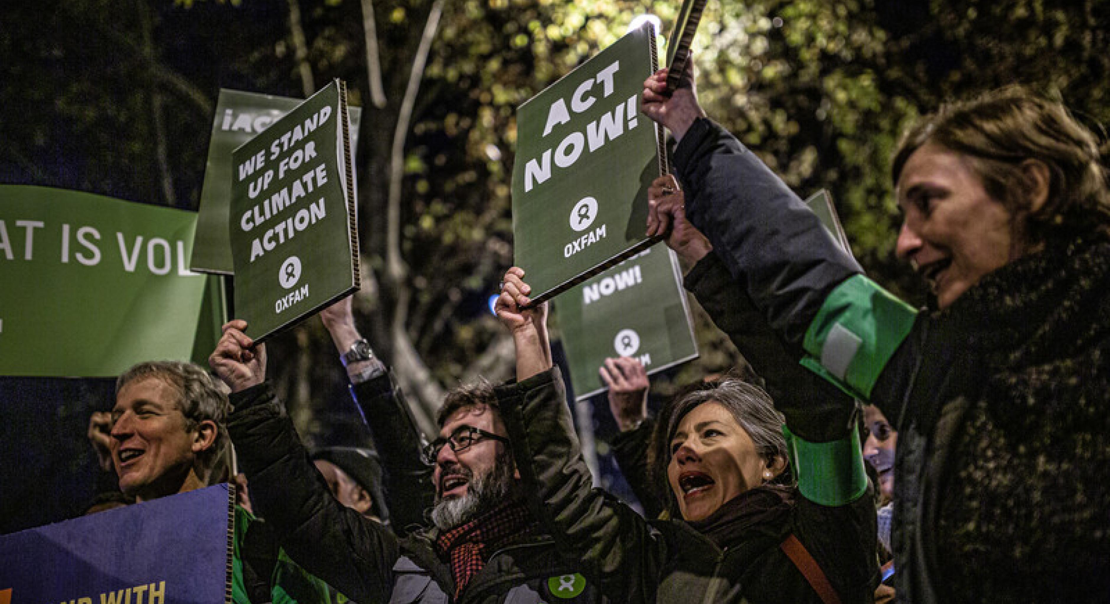 Menschen, die auf der Klimakundgebung zur 25. UN-Klimakonferenz protestieren, halten Schilder und Transparente hoch.