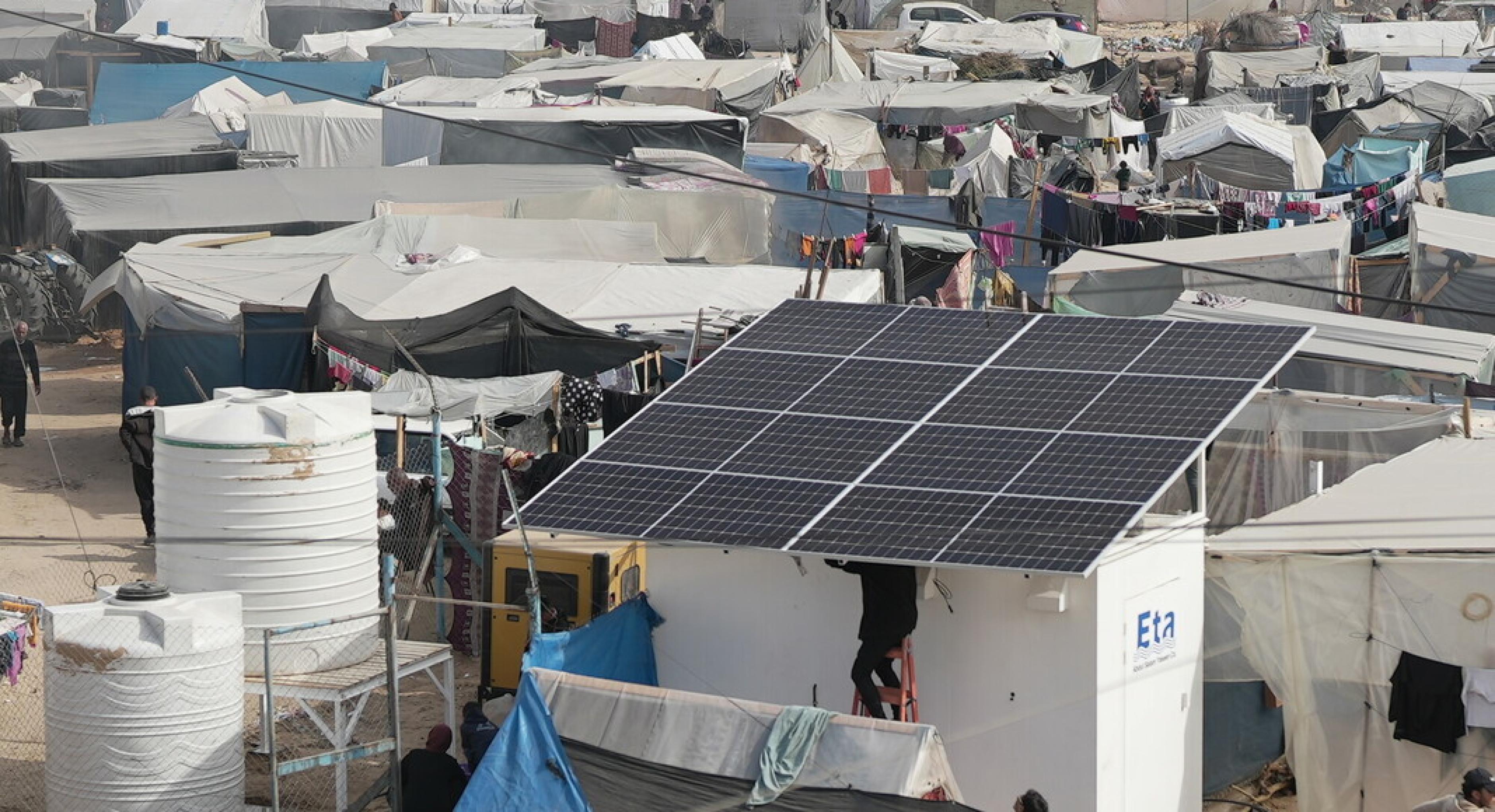 Entsalzungsanlage mit Solarpaneelen inmitten von Zelten im Gazastreifen