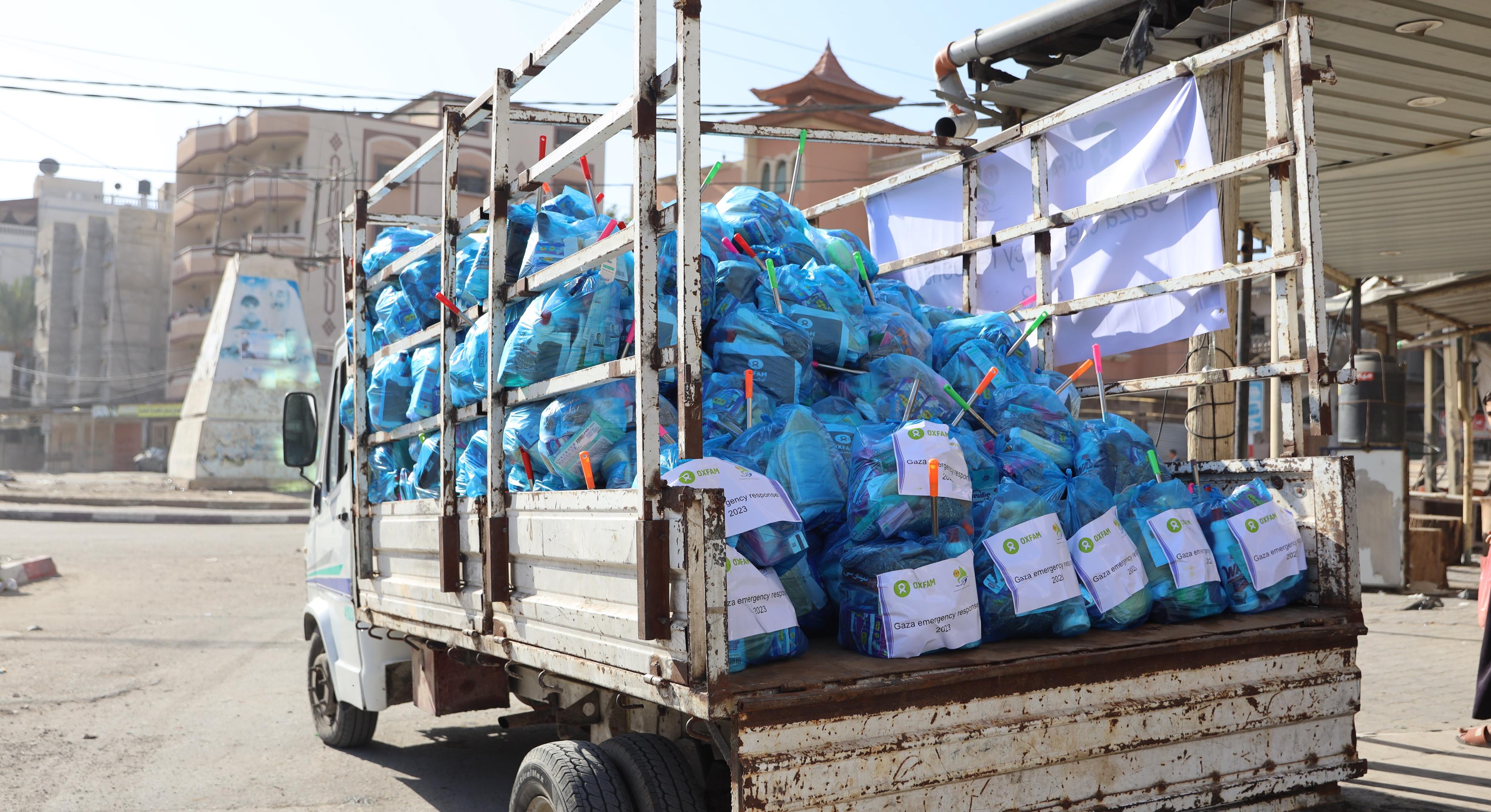 Ein rostiger Lastwagen transportiert mit Hilfsgütern gefüllte blaue Plastiksäcke