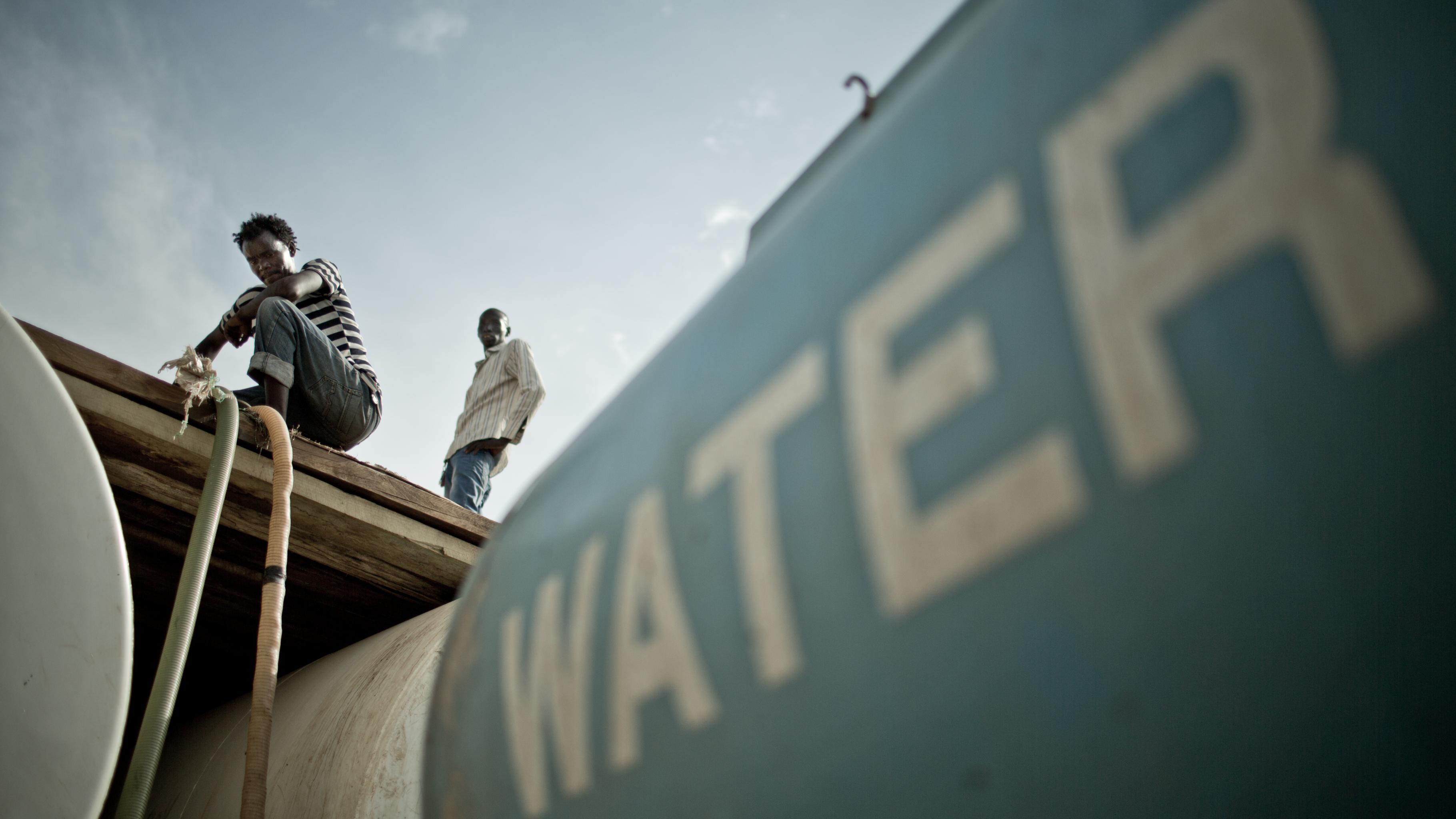 Wasser wird aus einem Wasserwagen gepumpt. 