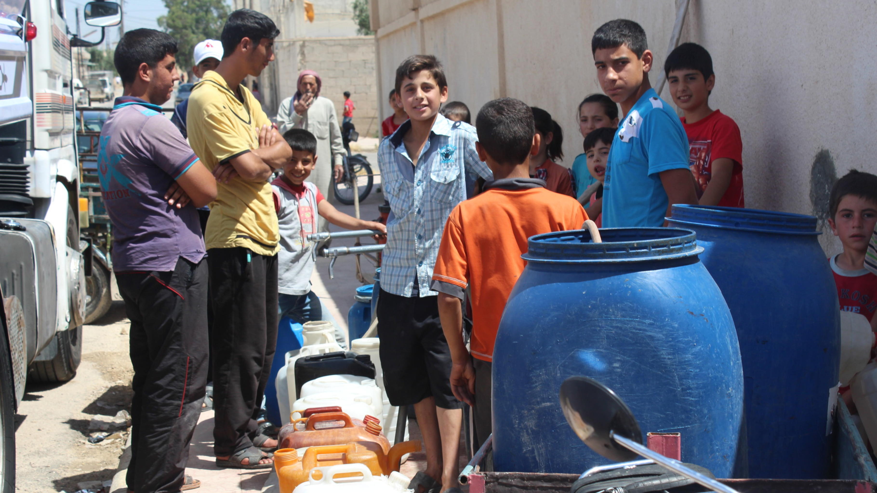 Menschen in Syrien stehen vor Wassertanks, die Oxfam geliefert hat.