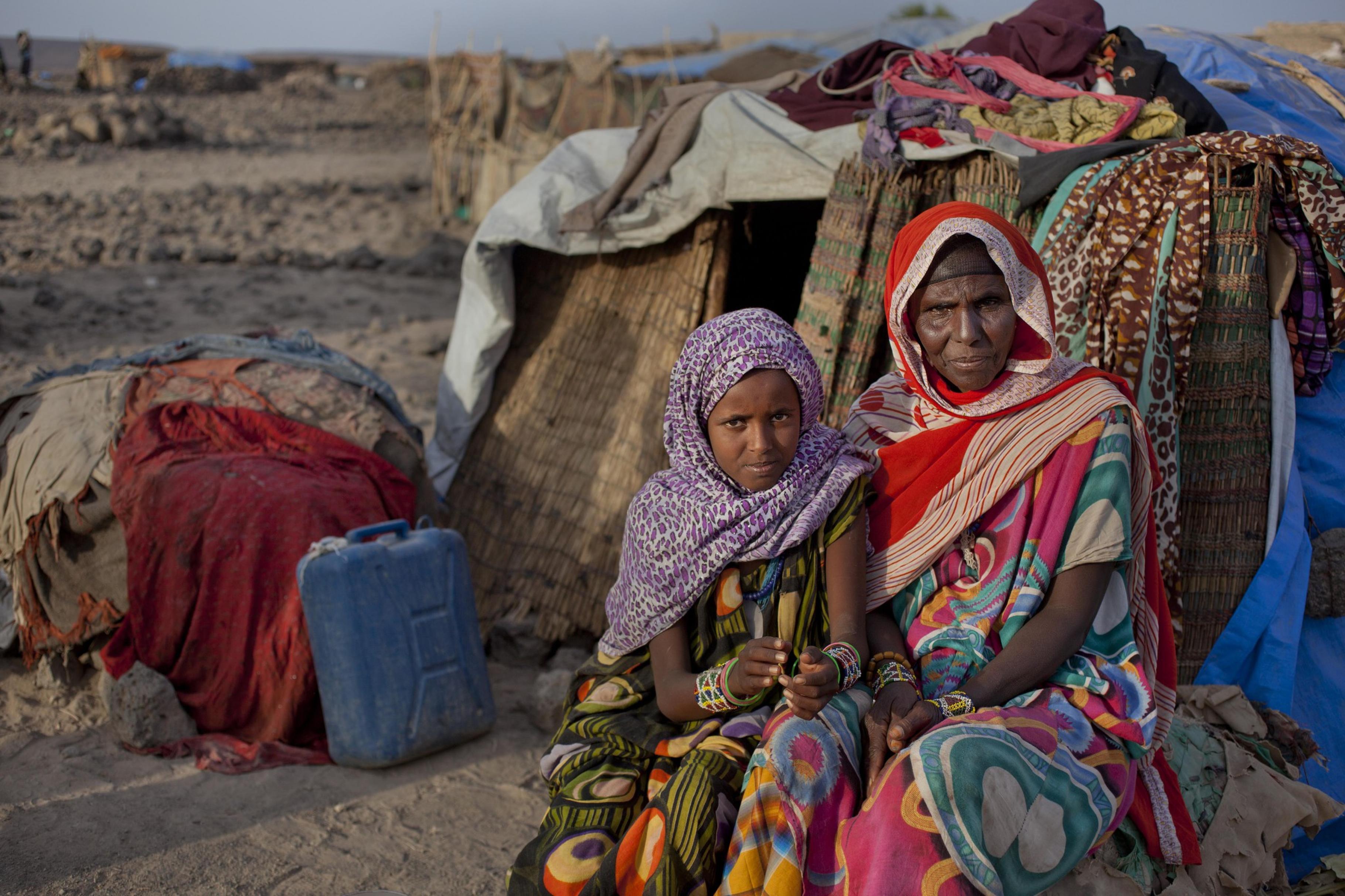 Eine Frau sitzt mit Ihrer Tochter für ihrem Haus in Äthiopien
