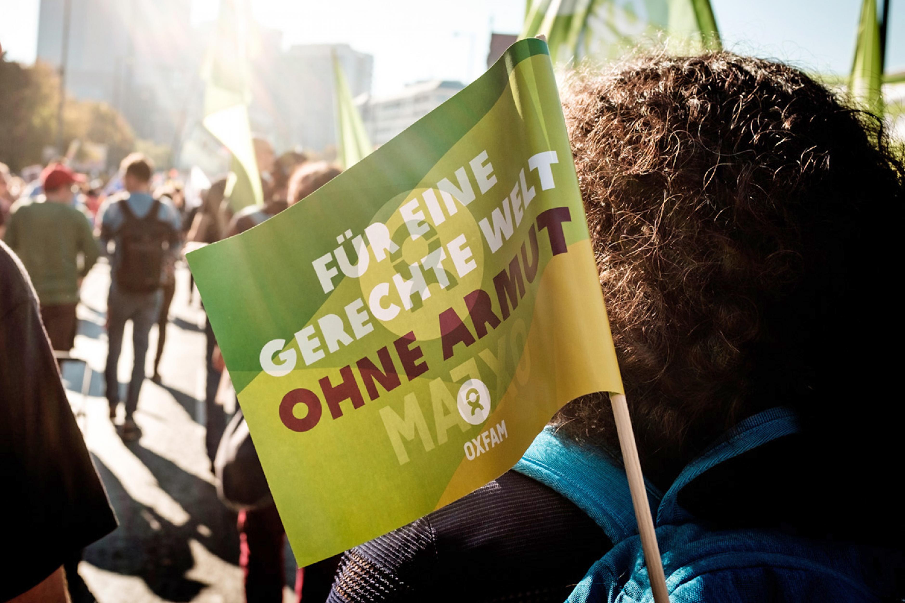 Eine Oxfam-Fahne ist auf einer Demonstration zu sehen