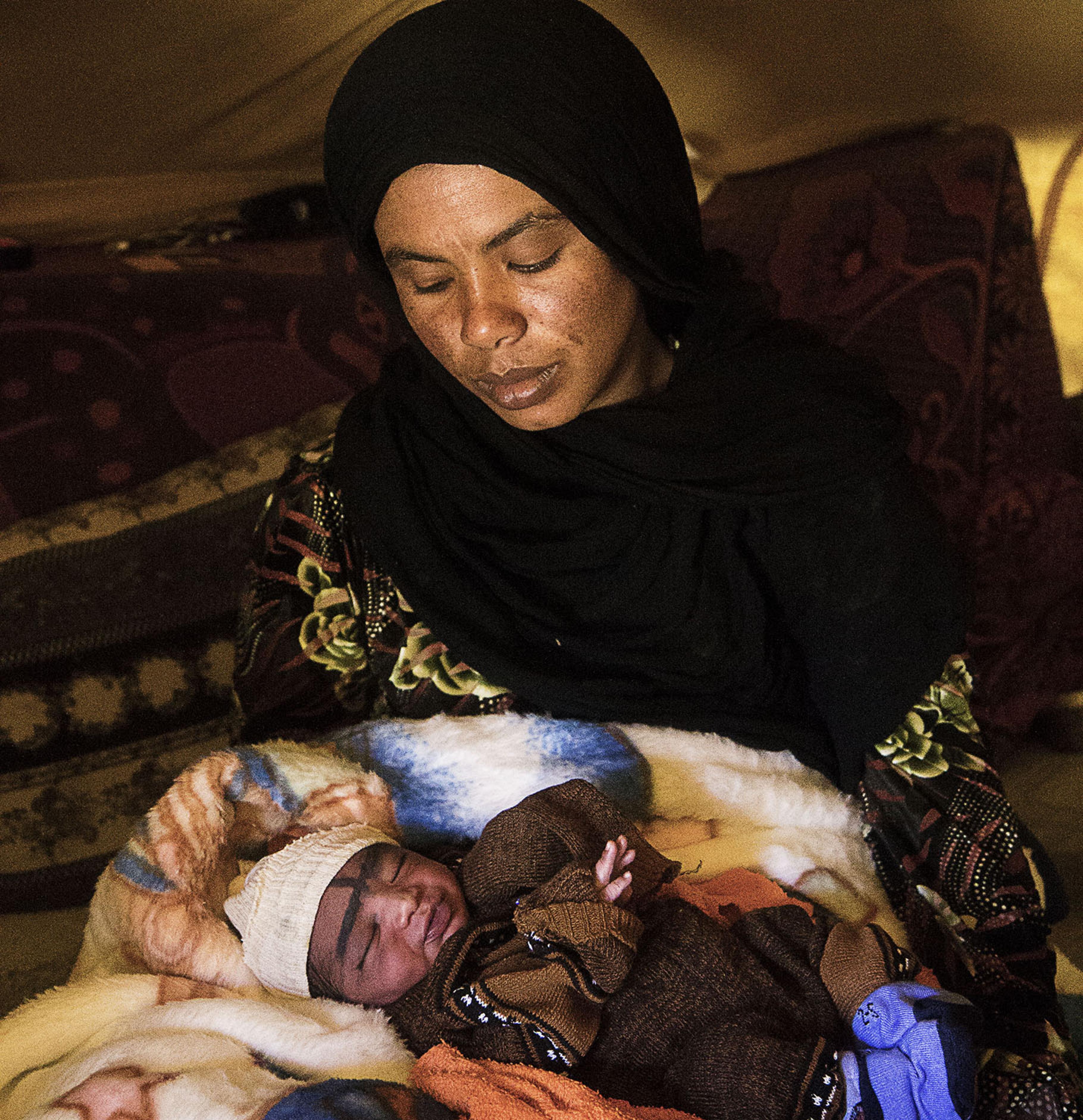 Hafsa hält ihr Neugeborenes im Arm