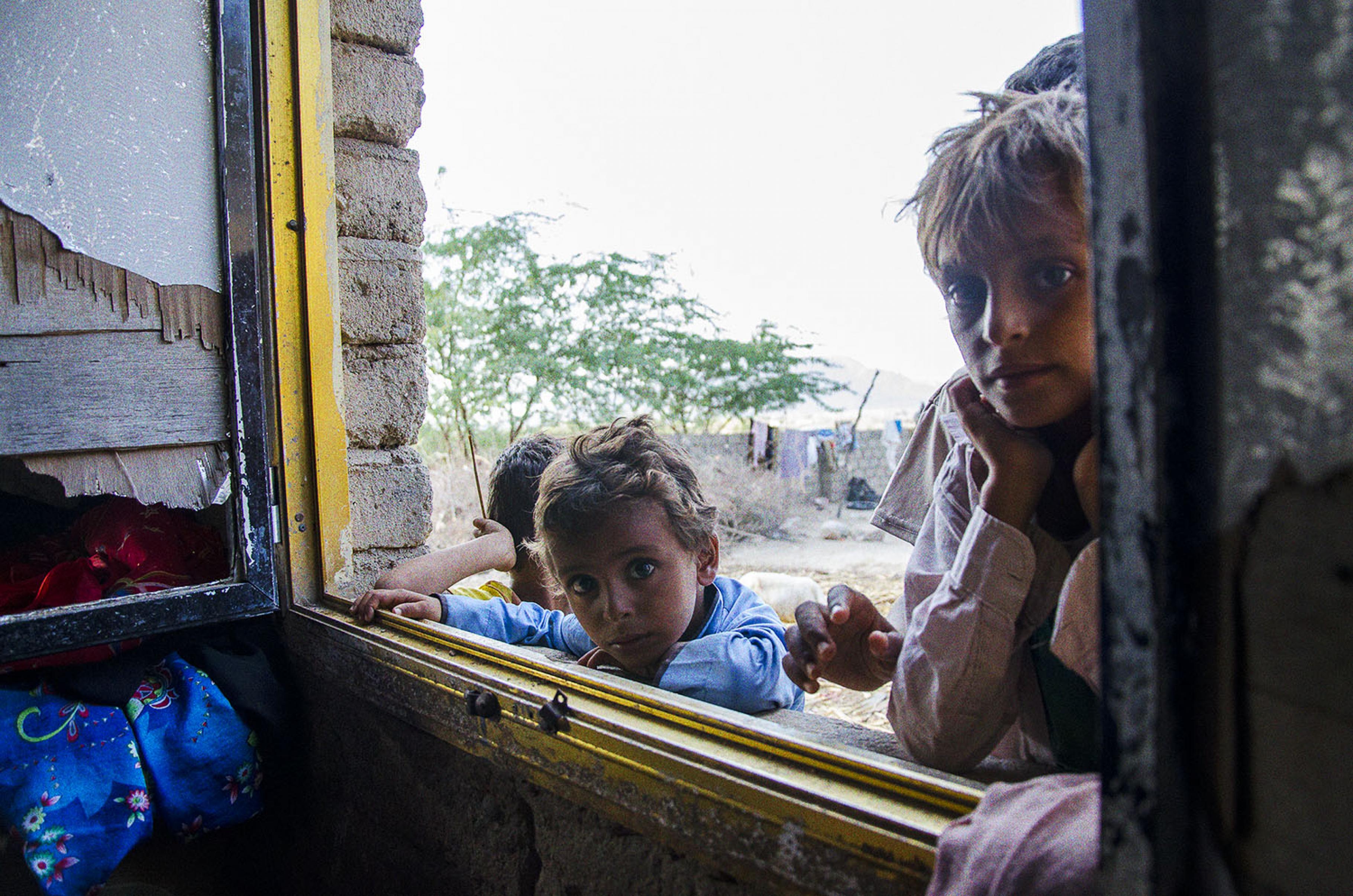 Kinder schauen durch Khamisas Fenster