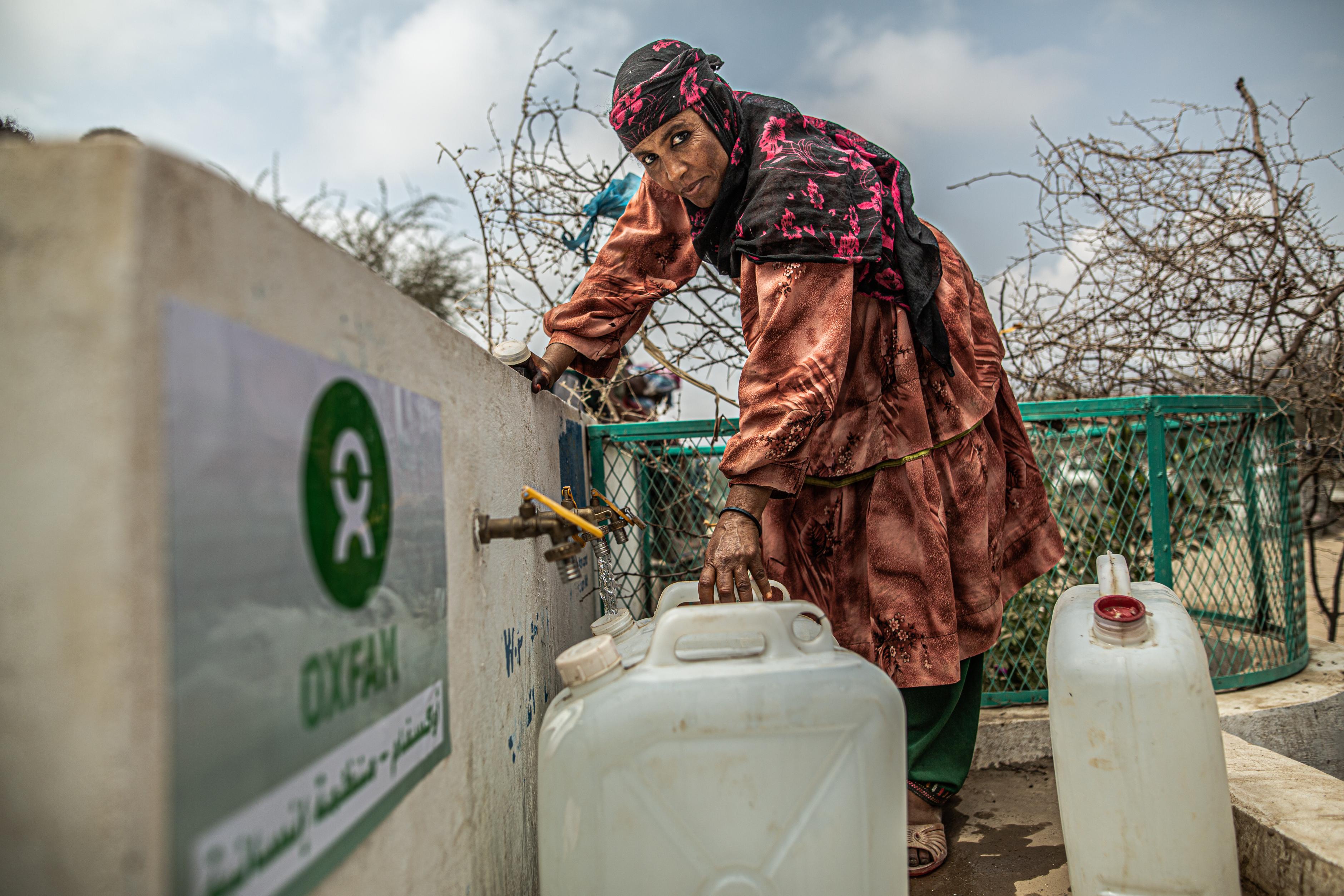 Samiha Ali befüllt einen Wasserkanister