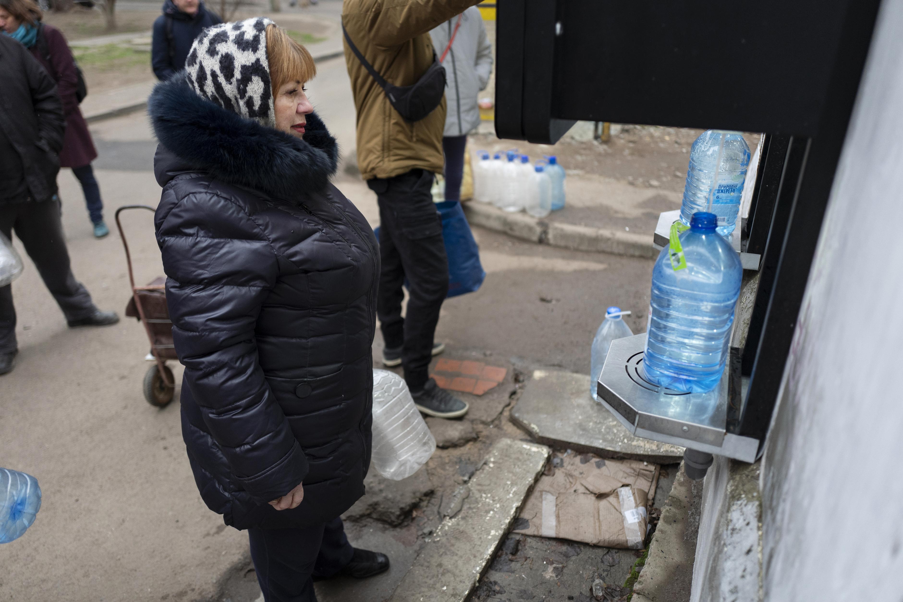 Eine Frau steht vor einem Automaten, aus dem Wasser herauskommt und in einen Plastikkanister fließt. Mit solchen Wasserstellen, stellt Oxfam weltweit Trinkwasser zur Verfügung.