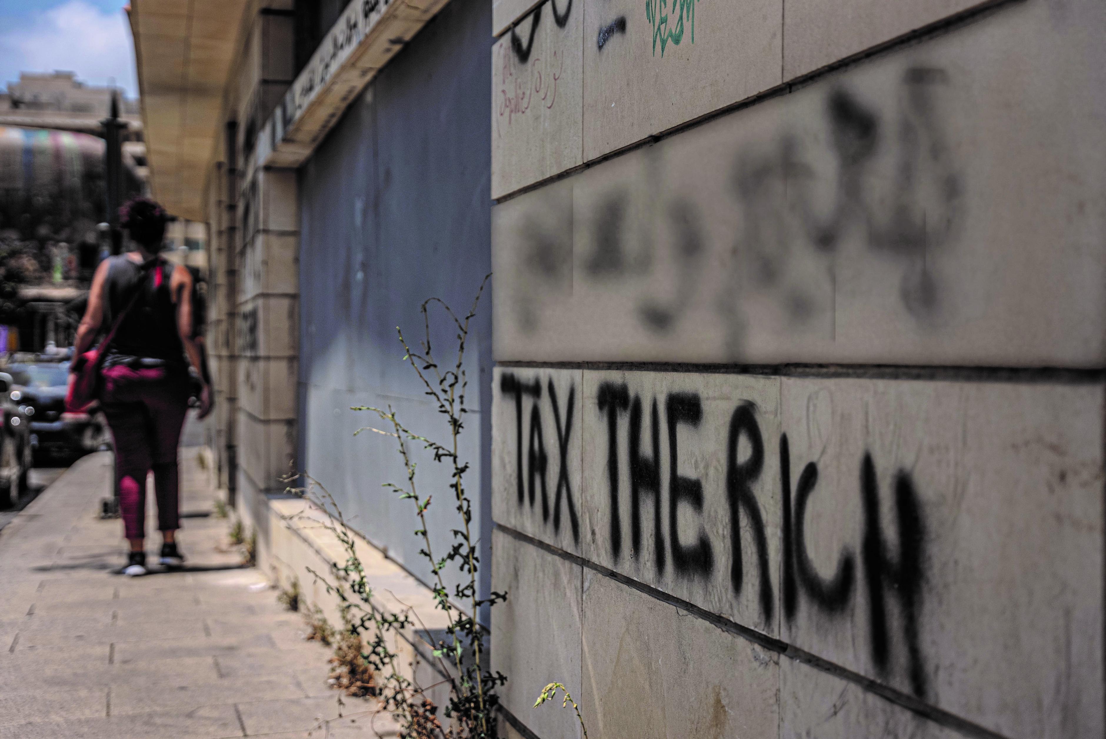 An einer Hauswand in der Innenstadt von Beirut, Libanon, steht das Graffiti „Tax the Rich“ („Besteuert die Reichen“) geschrieben.