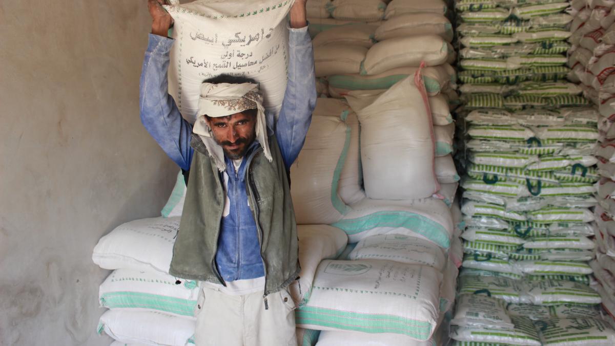 Ein Mann aus dem Jemen trägt einen Sack mit Weizen