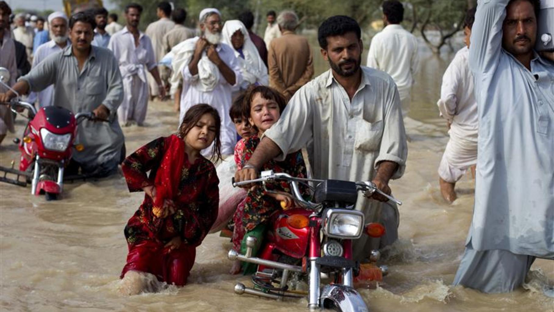 Foto: Ein Mann bringt seine Kinder in Sicherheit.