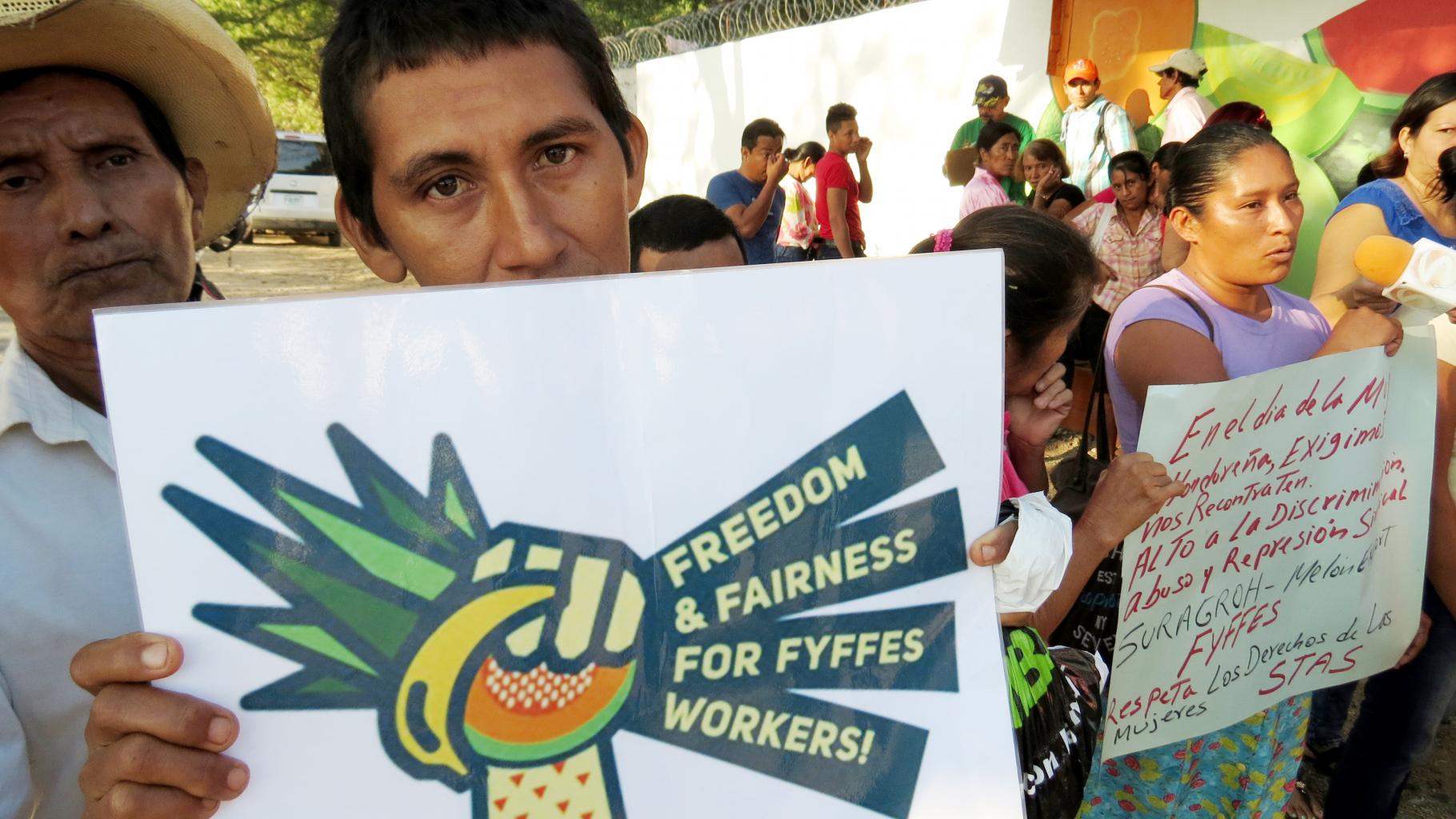 Ein Demonstrant hält ein Plakat in die Kamera: „Freedom and fairness for Fyffes workers!“