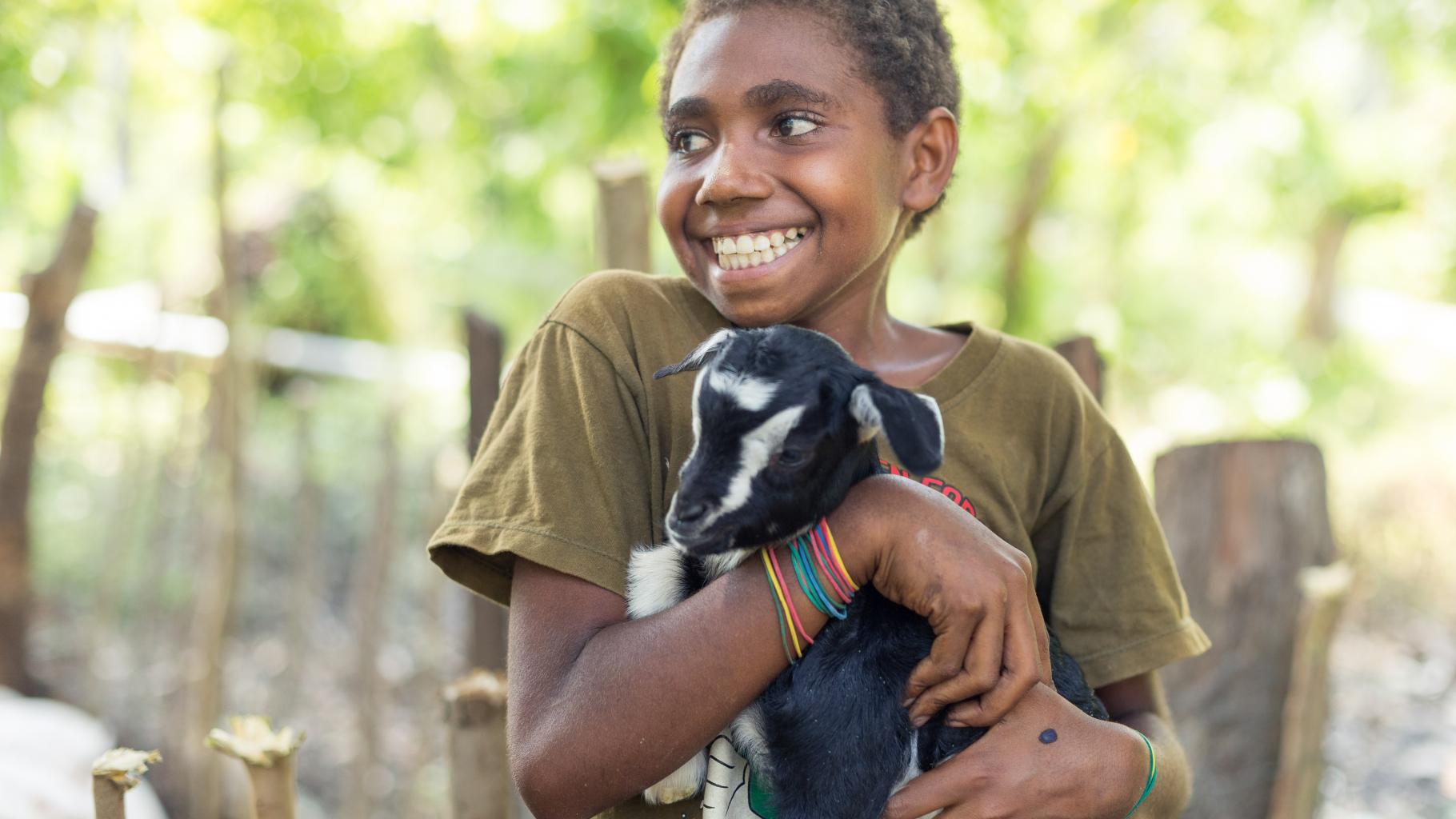 Jeanette (Name geändert) aus Vanuatu freut sich über eine Ziege, die ihrer Familie hilft, die Existenz zu sichern.