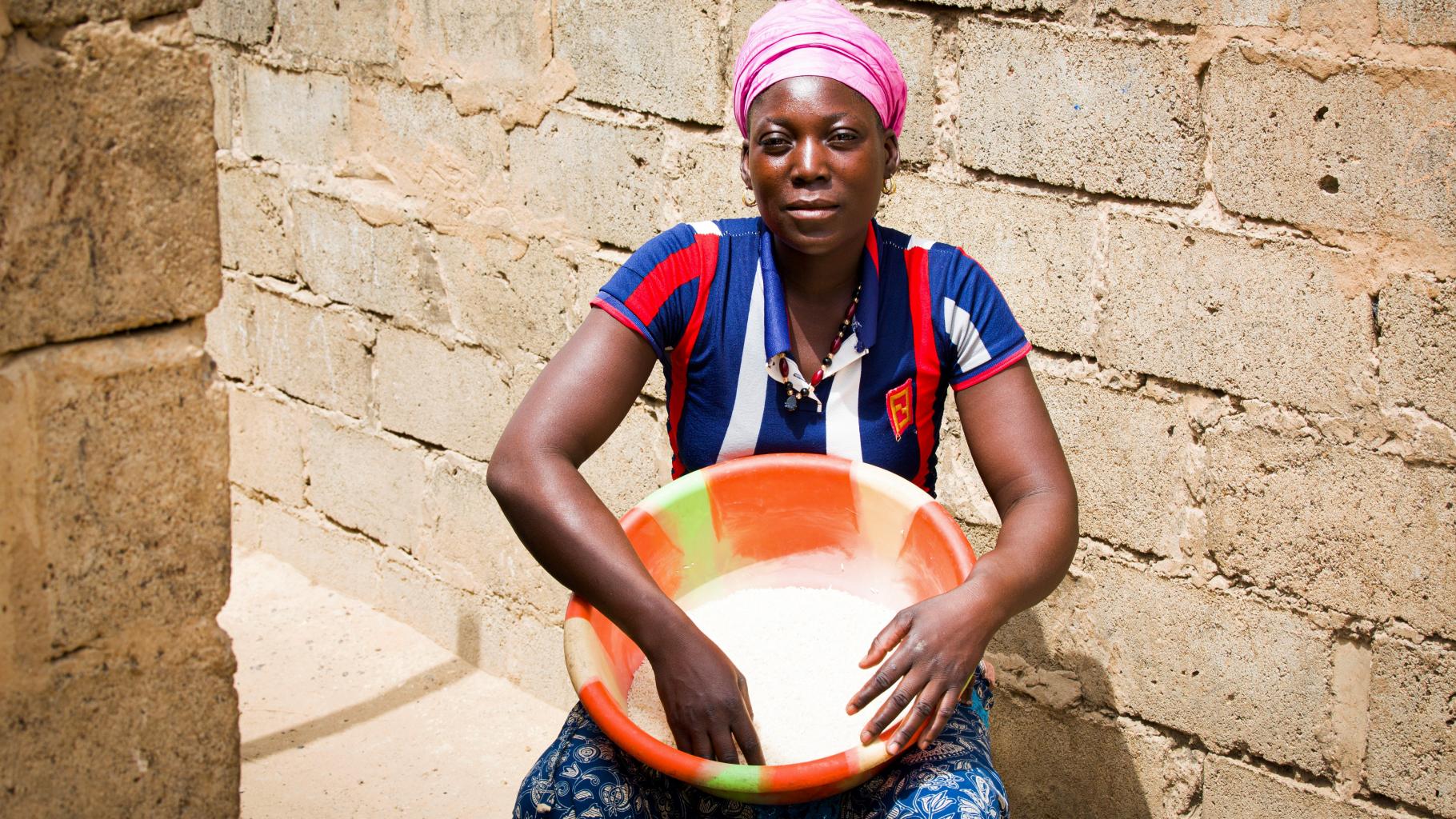 Zoré Fatimata wäscht Reis in einer großen Schale.