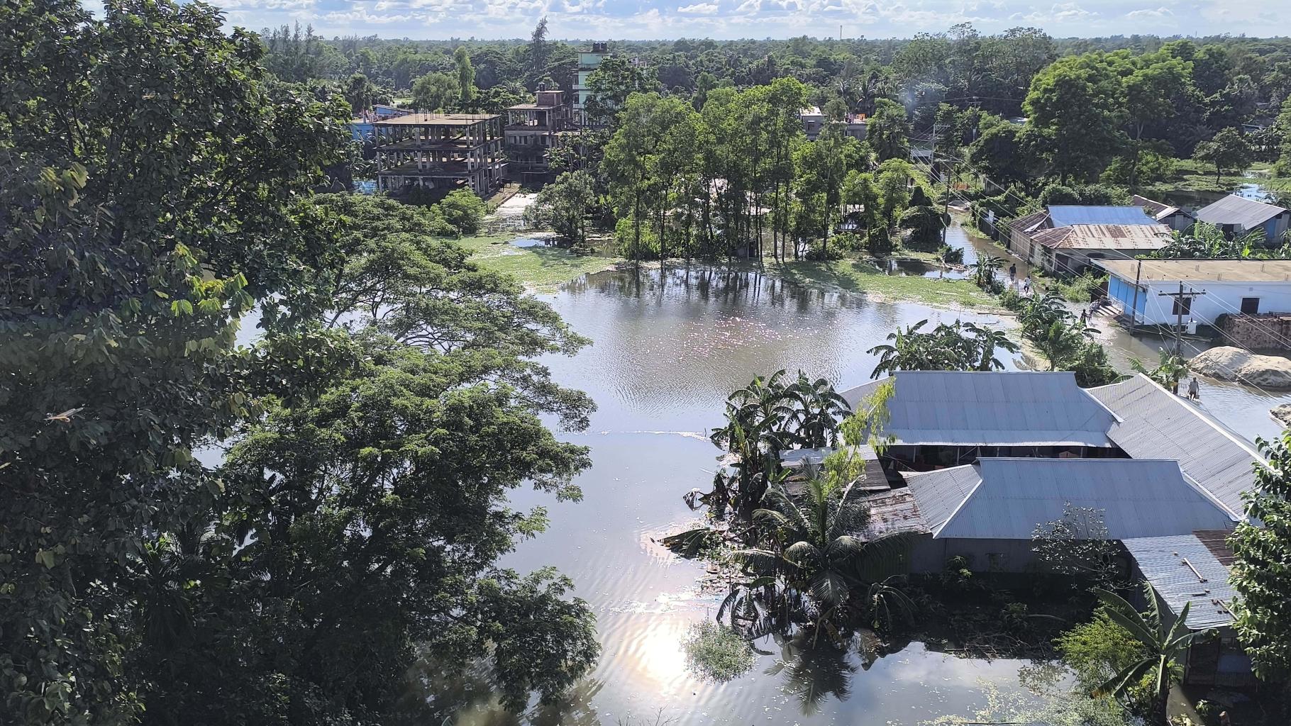 Eine von der Flutkatastrophe betroffene Gemeinde in Bangladesch kämpft mit den steigenden Wassermassen, die Häuser, Straßen und Ackerland überschwemmen.