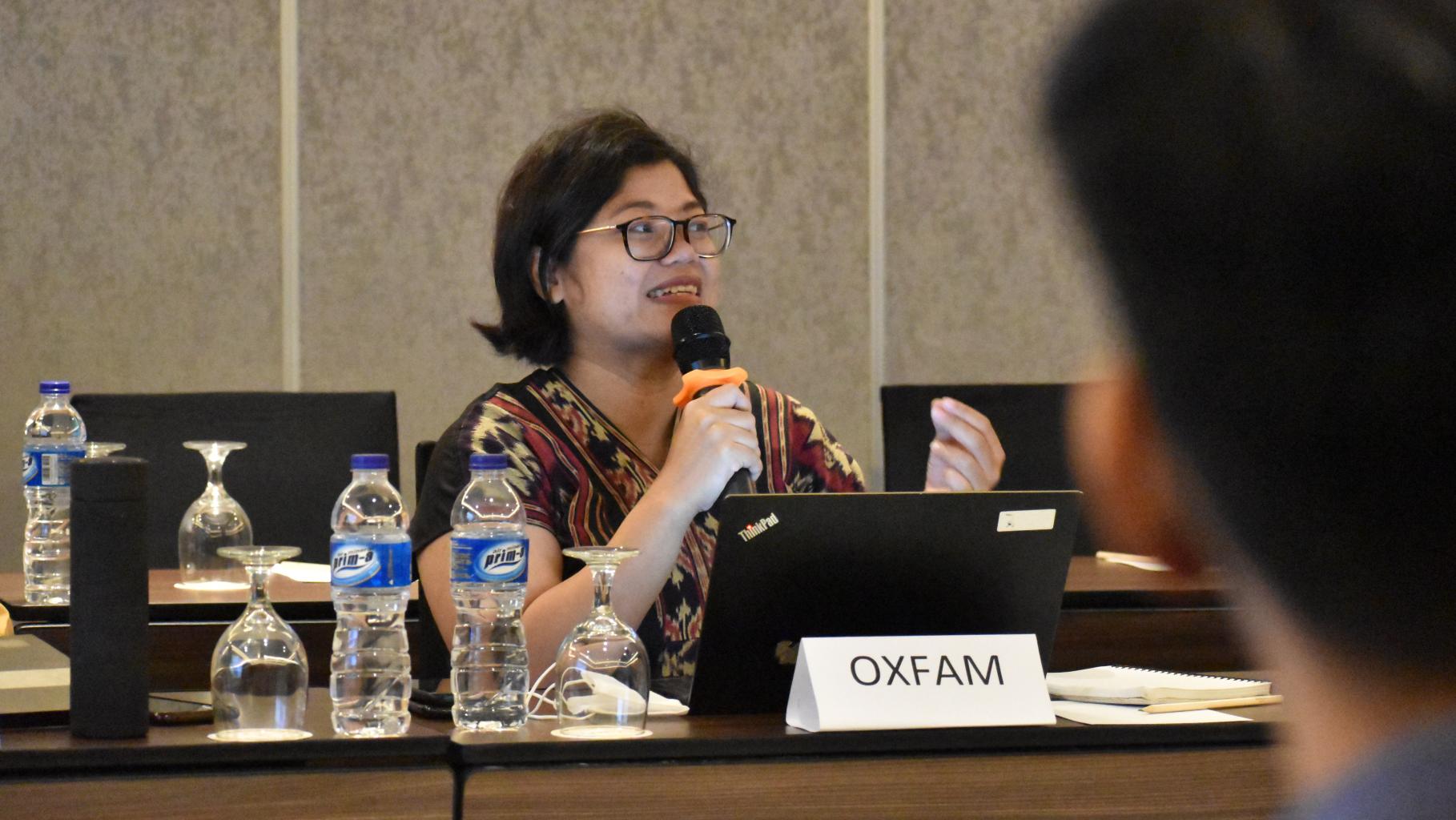 Maria Lauranti, Landesdirektorin für Oxfam in Indonesien, diskutiert bei einem Workshop mit Interessensvertreter*innen aus Indonesien. Sie sitzt an einem Tisch in einem Besprechungsraum und spricht gerade in ein Mikrofon.