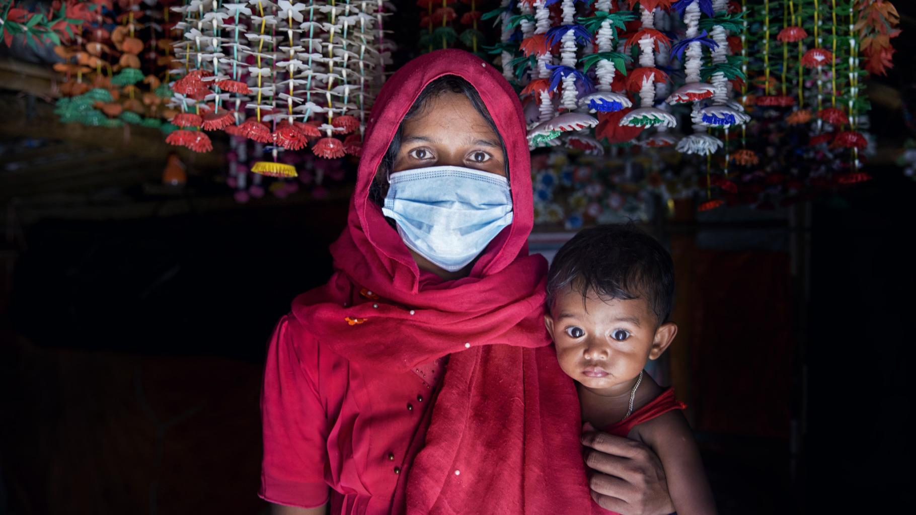 Rohingya-Frau mit Schutzmaske und Kind