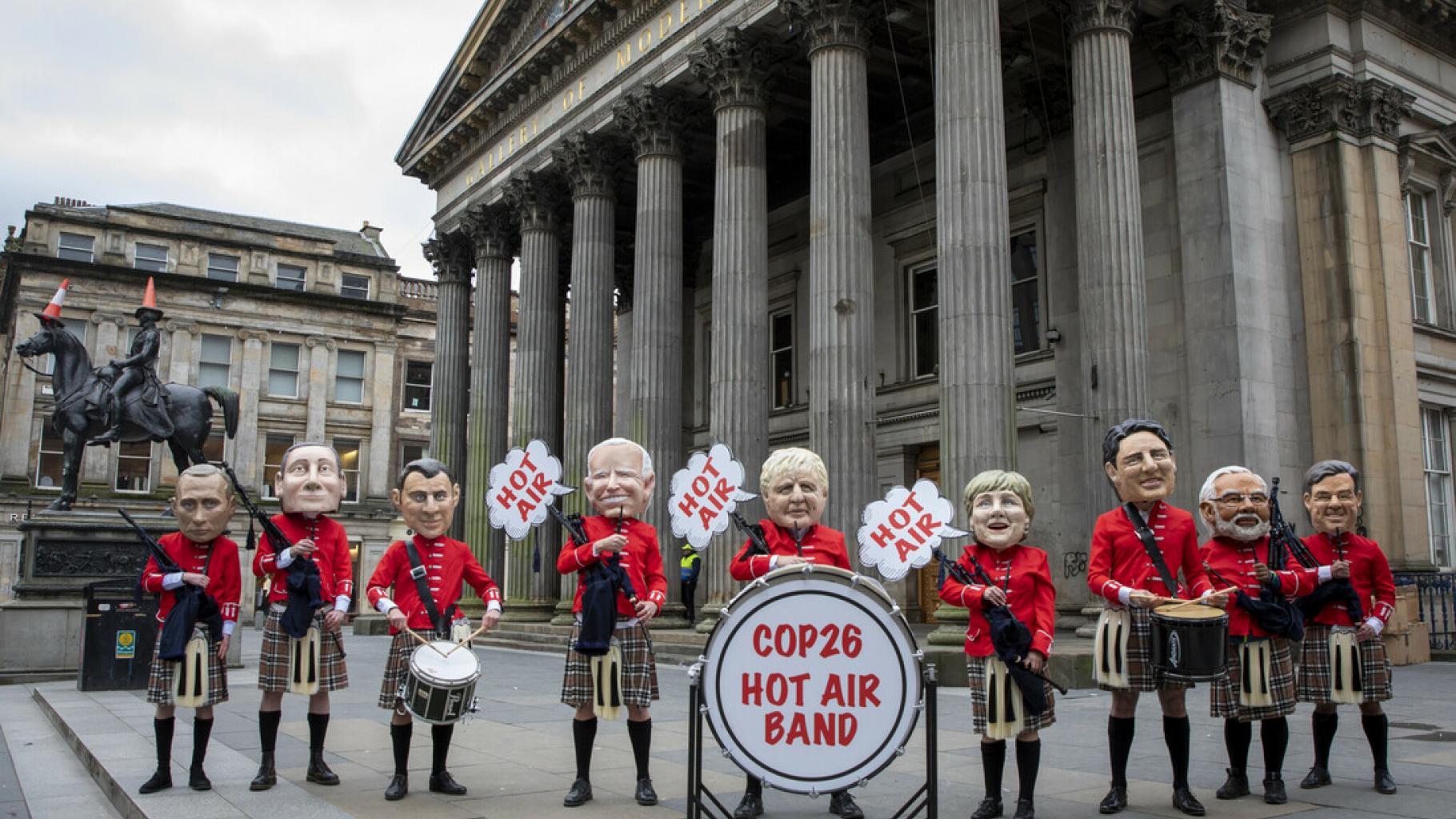 Figuren verschiedener Staatschef*innen posieren als „Hot Air Band“ („Heiße-Luft-Kapelle“). Sie tragen schottische Trachten und halten Dudelsäcke und Trommeln.