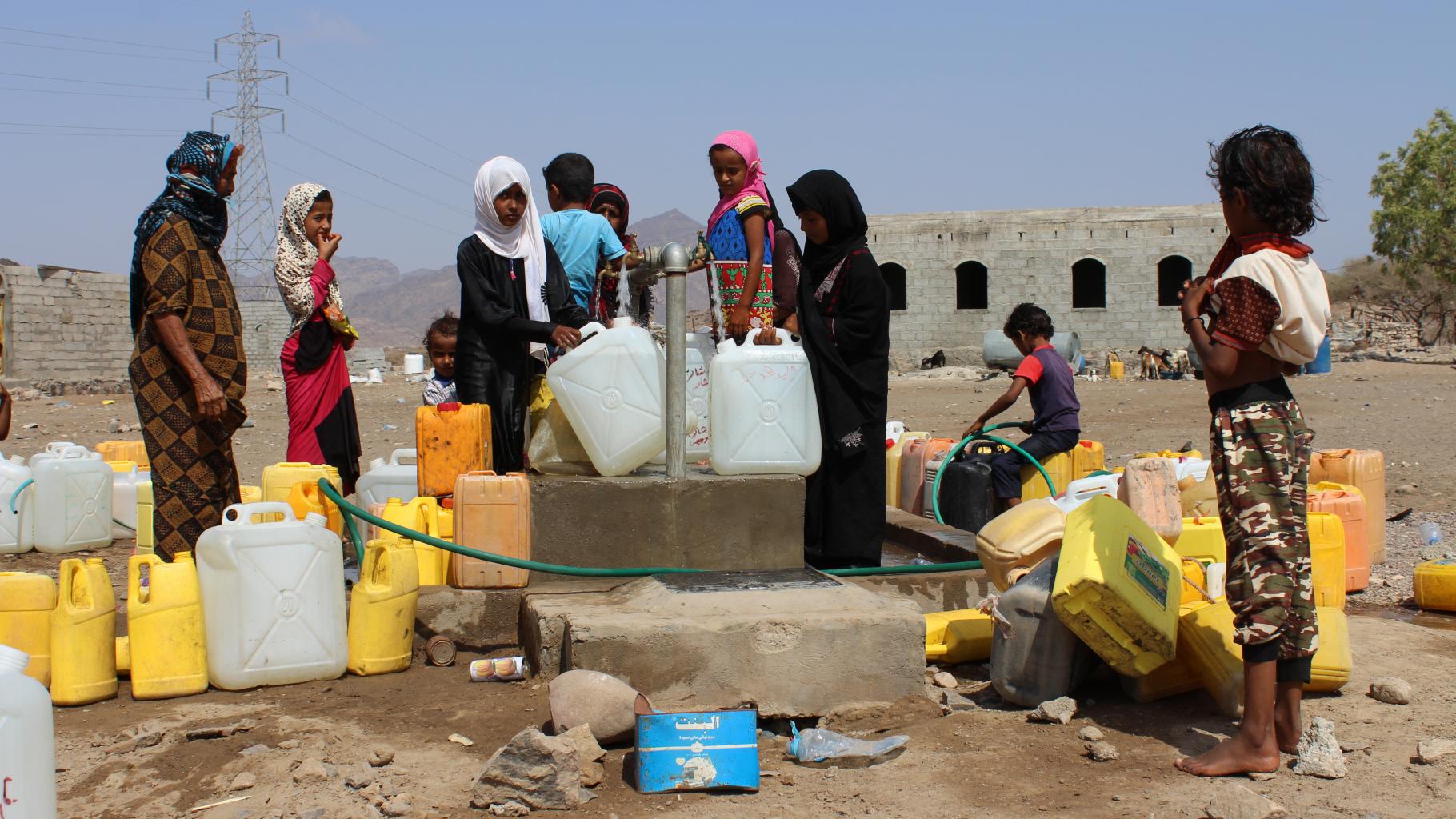 Frauen und Kinder an einer Wasserausgabestelle im Dorf Al-Dukm im Lahidsch Gourvernement.