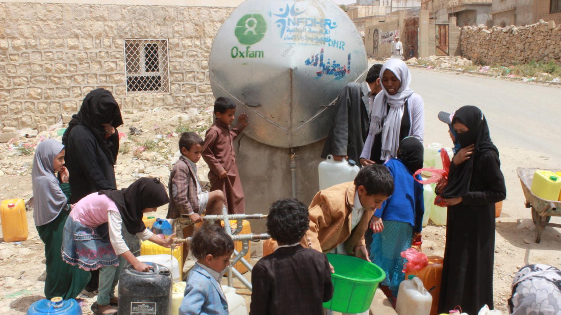 Frauen und Kinder holen Wasser an einem Tank in Khamir im Jemen.