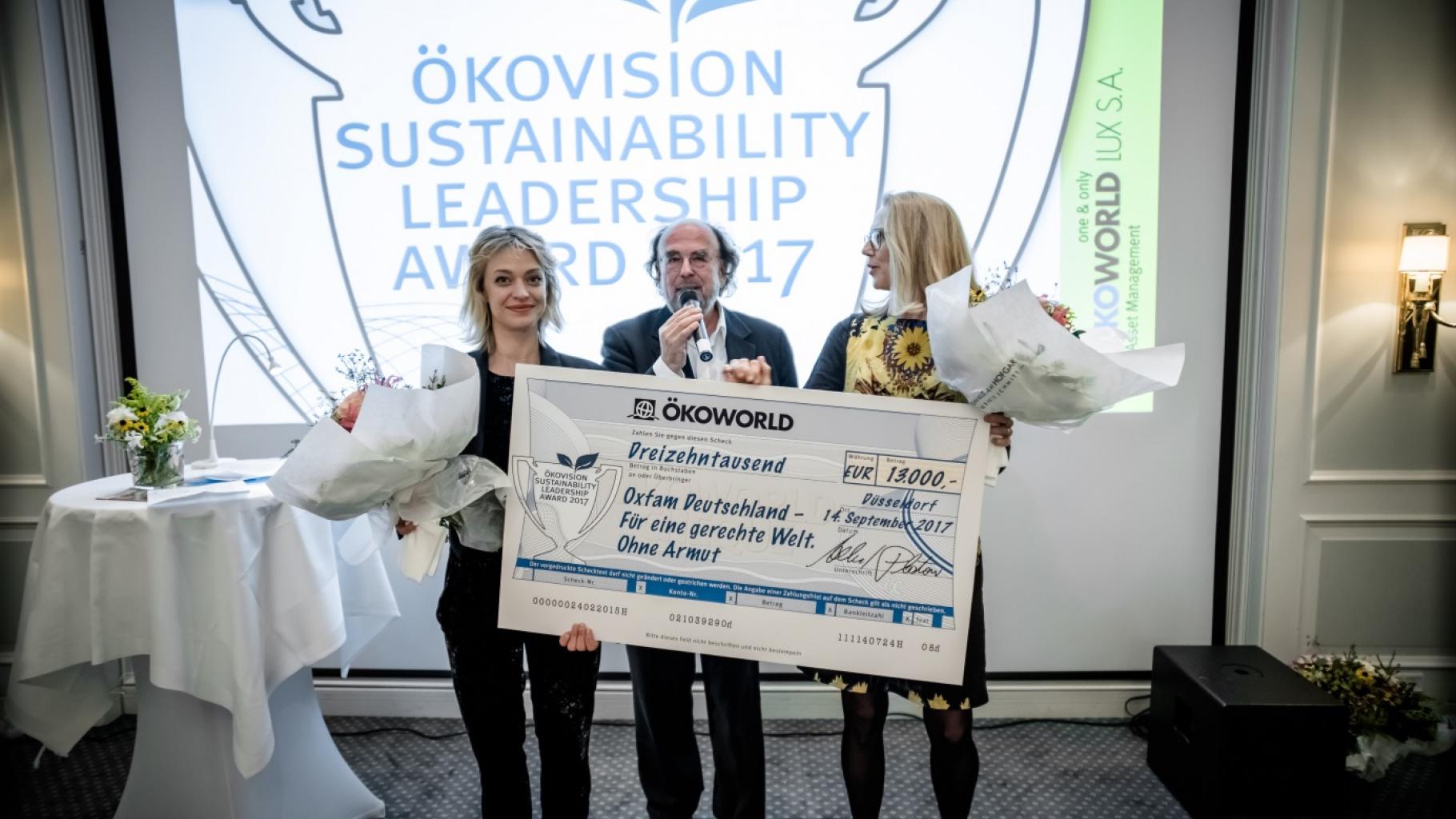 Alfred Platow, Gründer und Vorstandsvorsitzender von Ökoworld, übergibt Oxfam-Botschafterin Heike Makatsch und Geschäftsführerin Marion Lieser einen Scheck im Wert von 13.000 Euro.