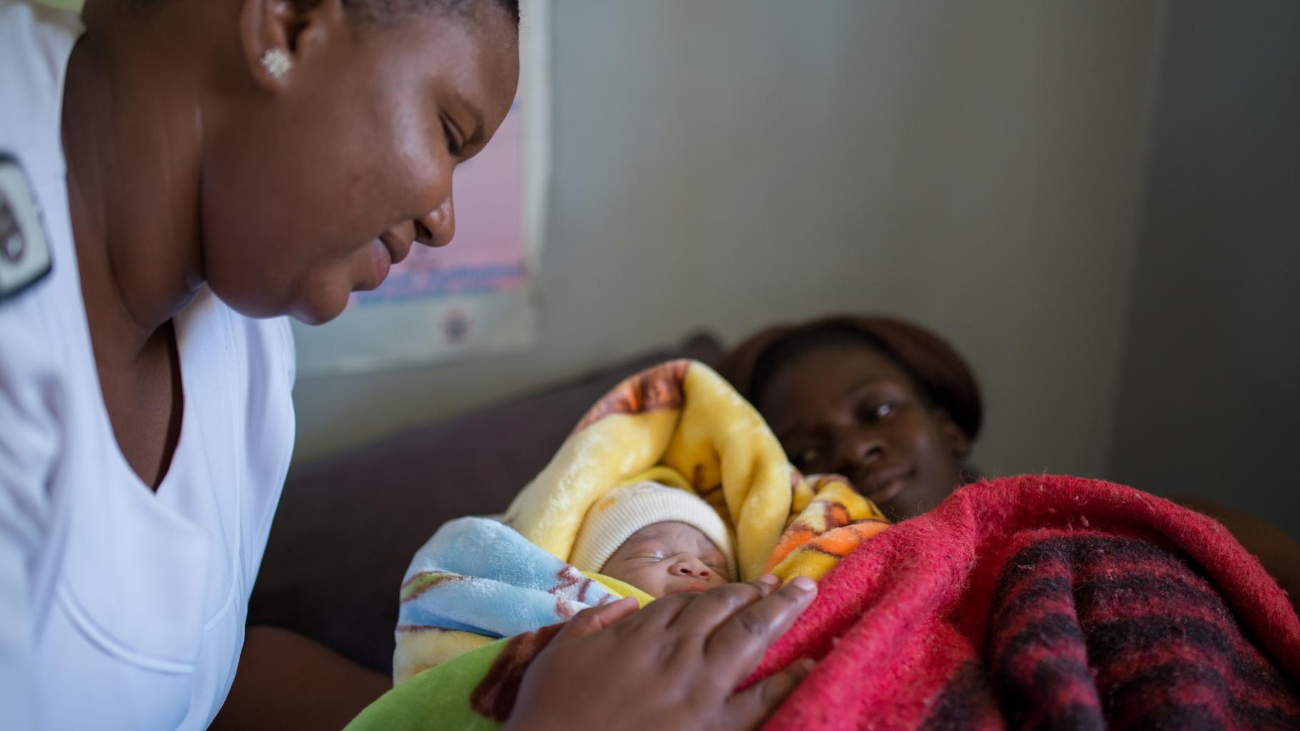Zwei Frauen mit einem neugeborenen Kind