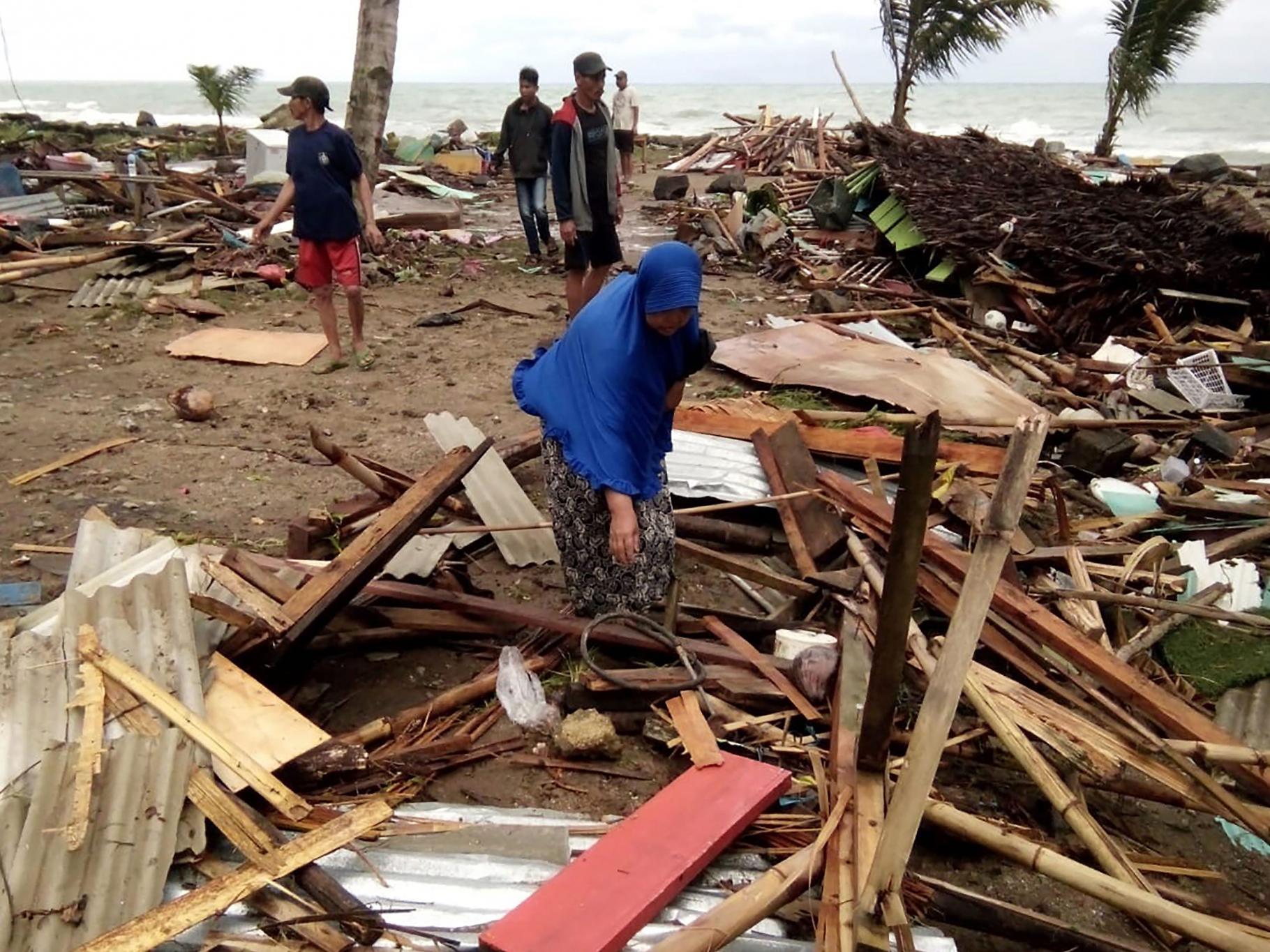 Frau am Carita Beach auf Jawa und das, was von ihrem Haus übrig geblieben ist