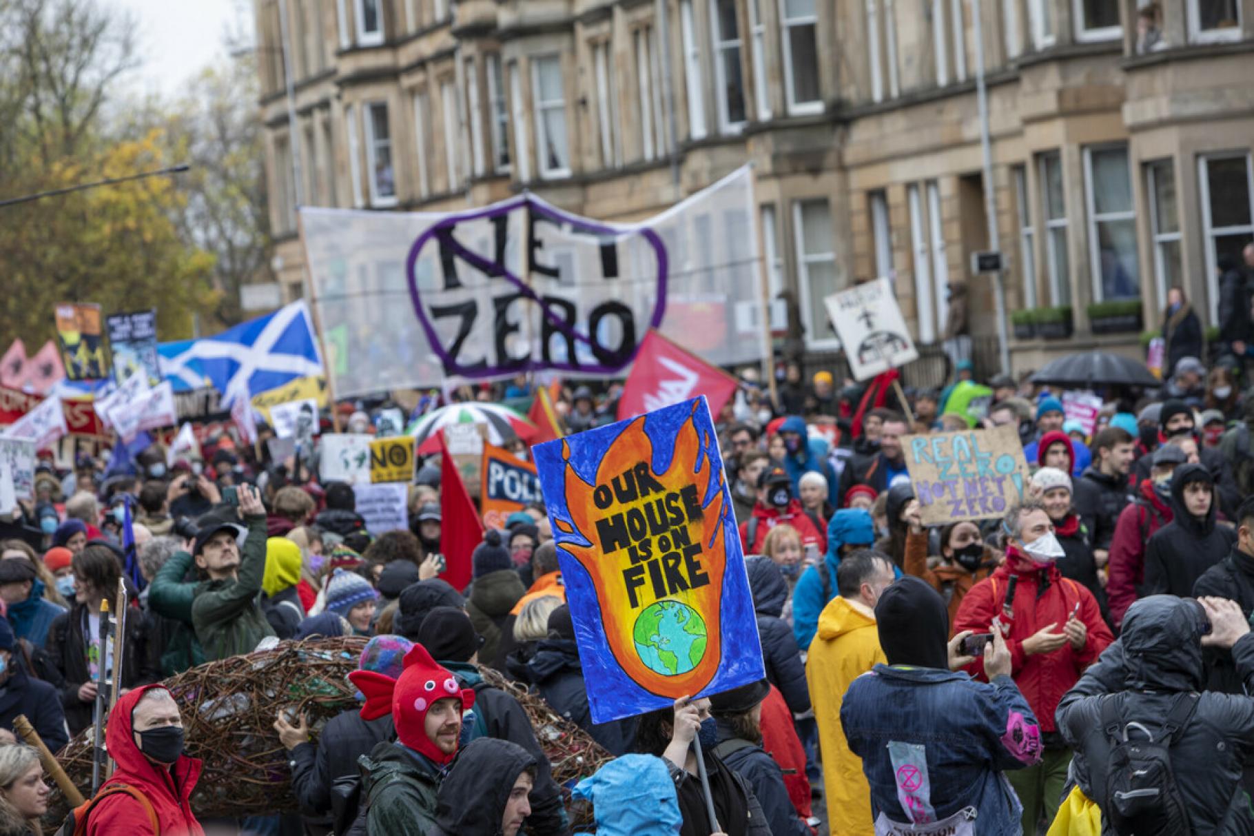 Menschen beim World Climate March, einer Demonstration für Klimagerechtigkeit, in Glasgow. Demonstriert wird beispielsweise gegen Greenwashing durch CO₂-Zertifikate.