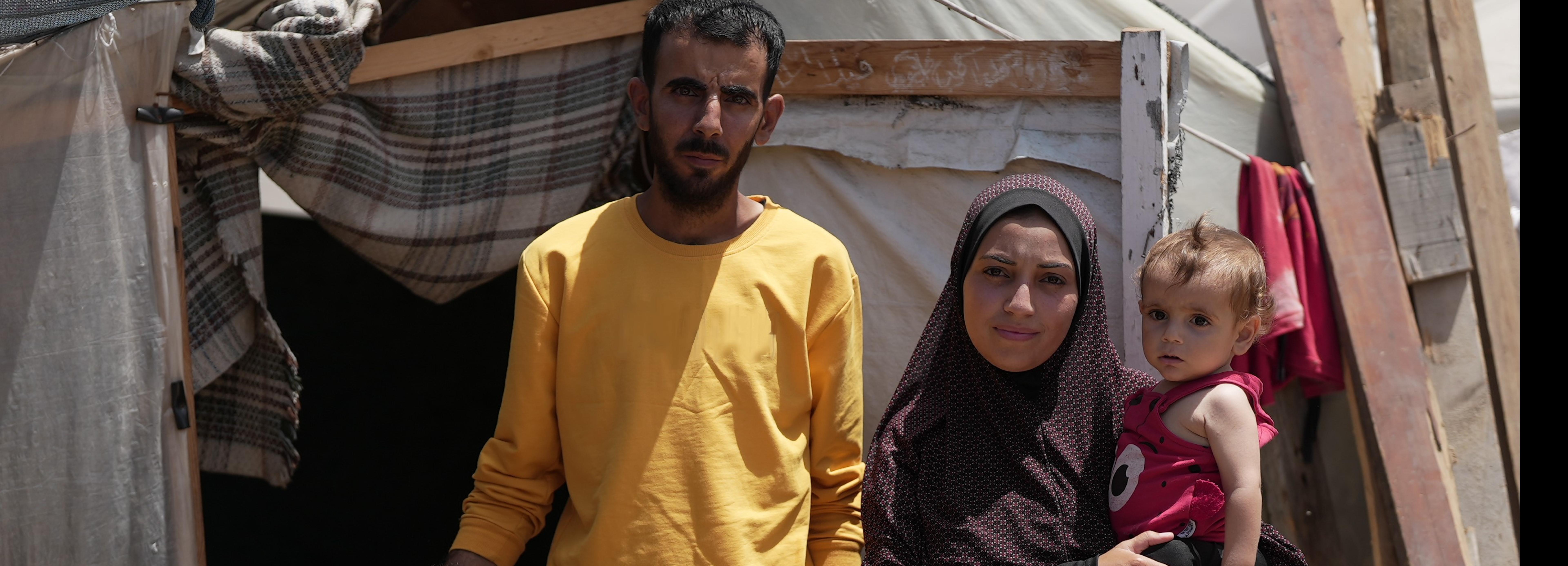 Eine Familie steht vor ihrem Zelt im Camp für Geflüchtete in Khan Yunis im Gazastreifen.