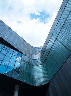 Die Geschäftspraktiken multinationaler Konzerne verschärfen die Ungleichheitskrise. Ein modernes Gebäude und Himmel von unten fotografiert.