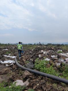 Zerstörte Wasserleitung in einem verlassenen und verwüsteten Camp für Geflüchtete in Rusayo. Zerwühlter Boden, Müll und dazwischen eine Wasserleitung, die eigentlich unter der Erde verlaufen sollte. Das Geflüchtetencamp in Rusayo ist verwüstet.