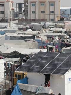 Entsalzungsanlage mit Solarpaneelen. Entsalzungsanlagen wie diese sollen auch im Rahmen des aktuellen Projektes aufgebaut werden. Sie liefern Trinkwasser für tausende Familien. Entsalzungsanlage mit Solarpaneelen inmitten von Zelten im Gazastreifen