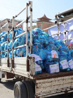 Im südlichen Gazastreifen verteilt Oxfams lokale Partnerorganisation Hygienesets Ein rostiger Lastwagen transportiert mit Hilfsgütern gefüllte blaue Plastiksäcke