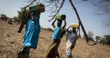 Frauen beim Wasserholen im ländlichen Burkina Faso Drei Frauen tragen Wasserbehälter